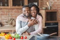 Grateful african woman hugging her husband at kitchen