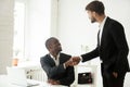 Grateful caucasian executive handshaking african employee congra Royalty Free Stock Photo
