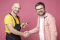 Grateful client makes a handshake gesture with a worker who did a good job, men look at the camera and smile. Royalty Free Stock Photo
