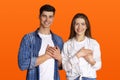 Grateful gesture concept. Pretty smiling young male and female in casual clothes keep hands on chest, being thankful Royalty Free Stock Photo