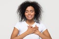 Grateful happy black woman holding hands on chest feeling thankful Royalty Free Stock Photo