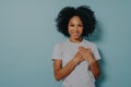 Grateful happy black woman holding hands on chest, satisfied african lady expressing love from heart