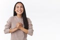 Grateful happy, smiling east-asian woman with long dark hair, clasp hands together pleased and delighted, thanking help Royalty Free Stock Photo