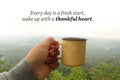 Grateful inspirational quote - Every day is a fresh start, wake up with a thank heart. Hand holding morning tea or coffee cup Royalty Free Stock Photo