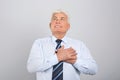 Grateful senior man with hands on chest against grey background Royalty Free Stock Photo