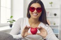 Grateful woman holding a red heart in front of the camera expressing gratitude to her audience. Royalty Free Stock Photo