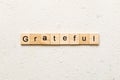 Grateful word written on wood block. Grateful text on table, concept