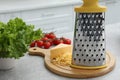 Grater, cheese and vegetables on table in kitchen Royalty Free Stock Photo