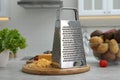 Grater, cheese and vegetables on table in kitchen Royalty Free Stock Photo