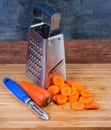 Grater, whole carrots and sliced into circles on cutting board