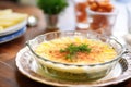 gratin dauphinois in a glass dish with parsley garnish
