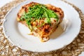 Gratin lasagne with fresh rucola leaf on white plate