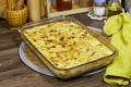 gratin of potato, chicken and mushrooms in Glass Dish on Kitchen Table Ready for Dinner. Royalty Free Stock Photo
