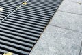 Grating of the drainage storm system on the pedestrian sidewalk. Royalty Free Stock Photo