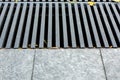 Grating of the drainage storm system on the pedestrian sidewalk. Royalty Free Stock Photo