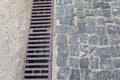 Grating of drainage system rainwater in the park at the sidewalk from a stone shaped paving slabs Royalty Free Stock Photo