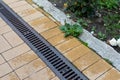 Grating of drainage system rainwater in the park at the sidewalk from a stone yellow paving slabs Royalty Free Stock Photo