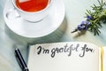 Gratitude journal with a flower and tea, with the handwritten phrase I am grateful for