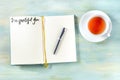 Gratitude journal with a pen and a cup of tea, with the handwritten phrase I am grateful for Royalty Free Stock Photo