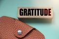 Gratitude word on wooden block and leather wallet. Donation charity foundation fundraising business concept