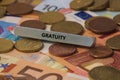 gratuity - the word was printed on a metal bar. the metal bar was placed on several banknotes