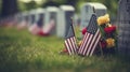 A grave with an american flag and colorful flowers are noticeable in the background for memorial day Royalty Free Stock Photo