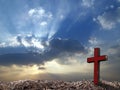 single antique red wooden cross on grave hill with sunray through clouds on dramatic sunrise sky Royalty Free Stock Photo