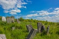 Grave stone ancient cemetery vivid green grass hill land scenic landscape environment bright colorful summer day time blue sky Royalty Free Stock Photo