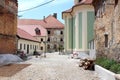 Gravel covered courtyard with concrete mixers and construction material surrounded with new buildings and old abandoned houses