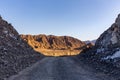 Gravel dirt road through rocky limestone Hajar Mountains and cliffs in United Arab Emirates