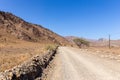 Gravel dirt road through rocky limestone Hajar Mountains and cliffs in United Arab Emirates Royalty Free Stock Photo