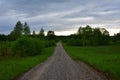 Gravel field road in wooded area after rain. Royalty Free Stock Photo