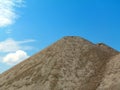 Gravel heaps under blue sky and white clouds