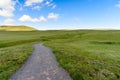 Gravel path through a meadow under blue sky in summer Royalty Free Stock Photo