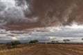 Gravel road en route to the Namibian desert with extremely dramatic sky, storm.