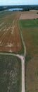 Gravel road on farmland fields and lake, aerial Royalty Free Stock Photo