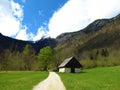 Gravel road leading next to cottage made of stone wood in Voje valley Royalty Free Stock Photo