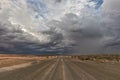 Gravel road with stormy sky, en route to the Namibia desert. Sossuvlei.