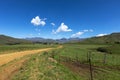 Gravel road wind through green landscape to the mountain