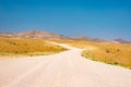 Gravel winding road crossing the colorful Namib desert, in the majestic Namib Naukluft National Park, best travel destination in Royalty Free Stock Photo