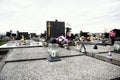 Graves, tombstones and crucifixes on traditional cemetery. Votive candles lantern and flowers on tomb stones in graveyard