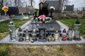 Graves, tombstones and crucifixes on traditional cemetery. Votive candles lantern and flowers on tomb stones in graveyard Royalty Free Stock Photo