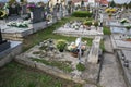 Graves, tombstones and crucifixes on traditional cemetery. Votive candles lantern and flowers on tomb stones in graveyard Royalty Free Stock Photo