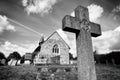 Gravestone Cross and Church in a Graveyard