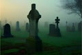 Gravestones in a misty graveyard with a cross in the foreground
