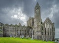 Graveyard with Celtic crosses and tombstones in front of majestic Rock of Cashel castle Royalty Free Stock Photo