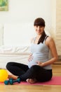 Gravid woman taking break from fitness exercises