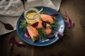 Gravlax graved salmon with beet root leaves salad, dill, Scandinavian mustard sauce on dark blue plate and wooden background with Royalty Free Stock Photo