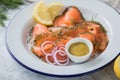 Gravlax a raw, marinated graved salmon with dill on enamel plate with Scandinavian mustard sauce, lemon, onion rings and linen