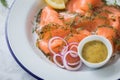 Gravlax a raw, marinated graved salmon with dill on enamel plate with Scandinavian mustard sauce, lemon, onion rings and linen Royalty Free Stock Photo